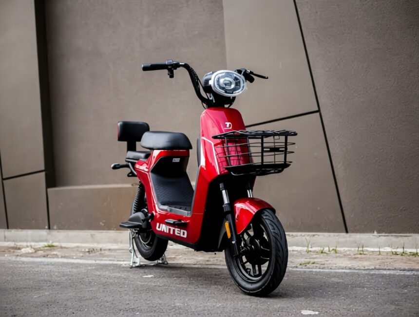 Red scooter with a front basket parked on a street in front of a brown wall, showing the 'UNITED' branding on the body.