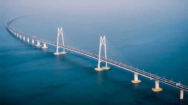 the-longest-bridge-in-the-world-the-danyang-kunshan-grand-v0-g93h92cnyzog1 - Mabur.co Suspension bridge spanning a calm blue ocean, featuring tall white towers and curved approach leads over the water.
