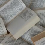 Several paperback books opened to pages, scattered in a pile and full of text.
