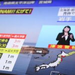 TV news screen showing a tsunami alert with a map of Japan and a sign-language interpreter in a blue box on the right