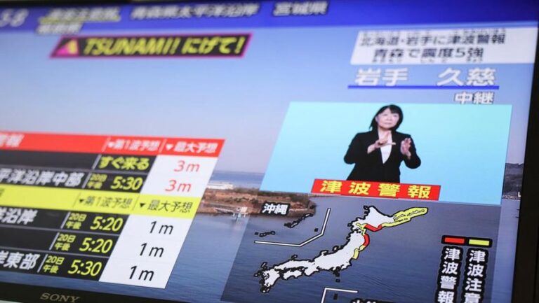 TV news screen showing a tsunami alert with a map of Japan and a sign-language interpreter in a blue box on the right
