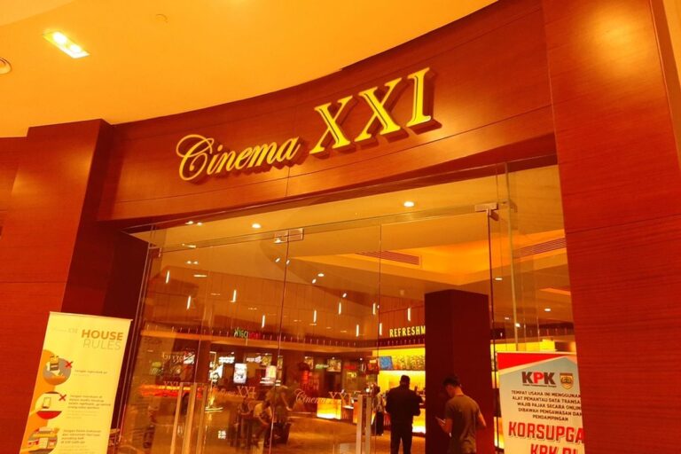 Entrance to Cinema XXI with glass doors and a warm wood facade