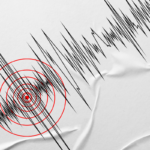 Seismograph recording with jagged black lines and red concentric circles marking a tremor focus on crumpled paper.