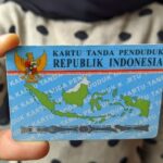 Indonesian ID card (KTP) with Garuda emblem and a map of Indonesia being held by a person.