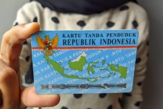 Indonesian ID card (KTP) with Garuda emblem and a map of Indonesia being held by a person.