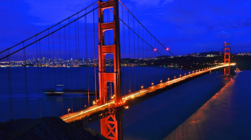 uiiooo - Mabur.co Golden Gate Bridge lit in orange at night, spanning San Francisco Bay with the city lights in the distance.