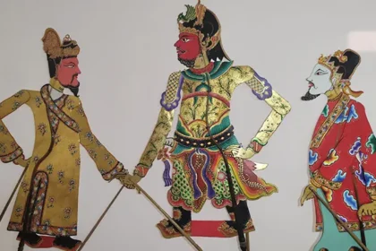 Three ornate warrior figures in colorful traditional robes, standing with swords, mid-heroic scene.