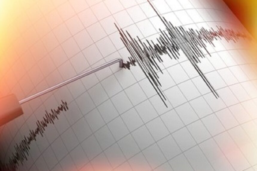 ECG tracing on grid paper showing a sharp heartbeat spike with a pen-like electrode nearby