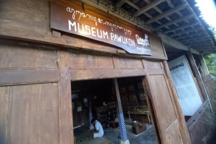 Entrance to a wooden museum with a sign 'MUSEUM PAWUKON' above the doorway