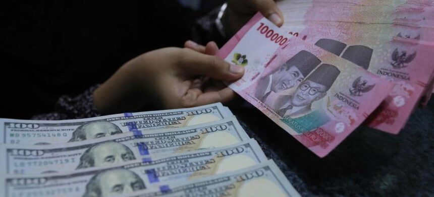 Close-up of hands counting US $100 bills and Indonesian 100,000 rupiah notes.