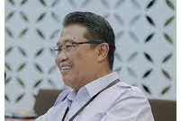 yuop - Mabur.co Smiling man wearing glasses in an office, seated at a conference table.