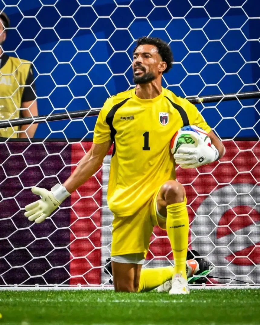 🚨 THE NIGHT THE WORLD STOOD STILL FOR CAPE VERDE 🇨🇻🌍40-year-old goalkeeper Vozinha turned - Mabur.co Soccer goalkeeper in a yellow kit kneels by the goal, holding a ball under his right arm with gloves on.